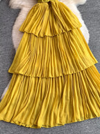 Mustard yellow pleated layered spaghetti-strap midi dress, skirt detail.