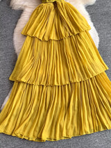 Mustard yellow pleated layered spaghetti-strap midi dress, skirt detail.