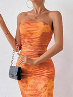 Orange printed strapless side-slit maxi dress, neckline detail.