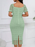 Sage green short-sleeve lace midi dress with slit, back view.