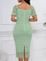 Sage green short-sleeve lace midi dress with slit, back view.