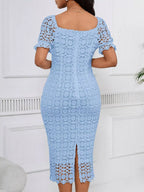 Light blue short-sleeve lace midi dress with slit, back view.