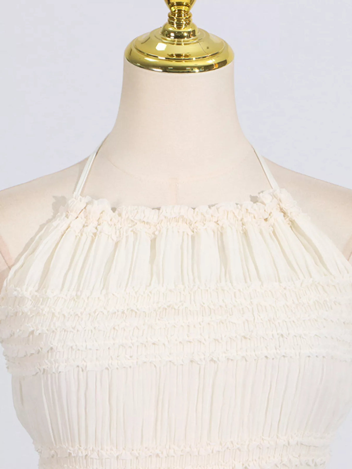 Ivory ruched halter neck maxi dress, neckline detail.