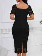 Black short-sleeve lace midi dress with slit, back view.