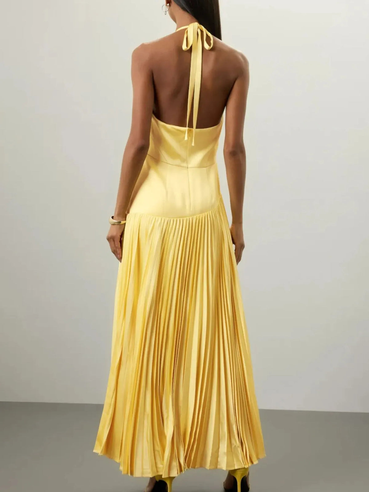 Yellow pleated halter-neck maxi dress, back view.