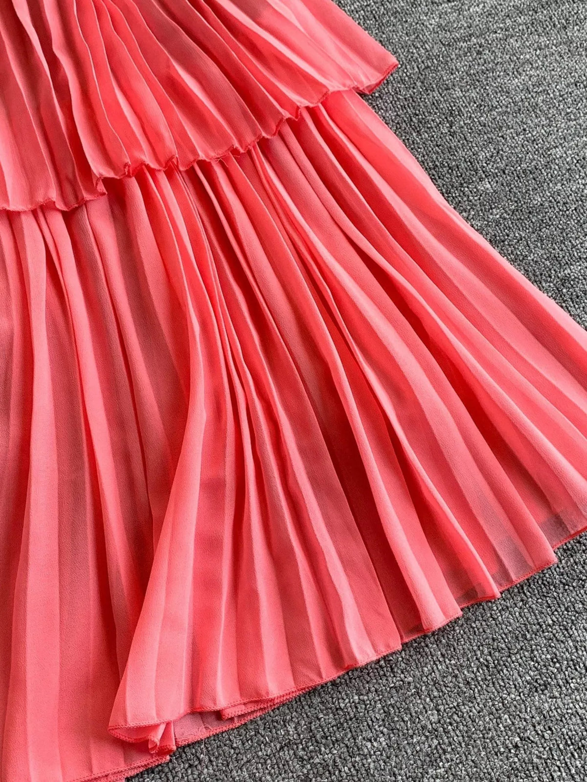 Pink pleated layered spaghetti-strap midi dress, pleat detail.