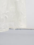 White sleeveless floral appliqué midi dress, hem detail.