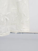 White sleeveless floral appliqué midi dress, hem detail.