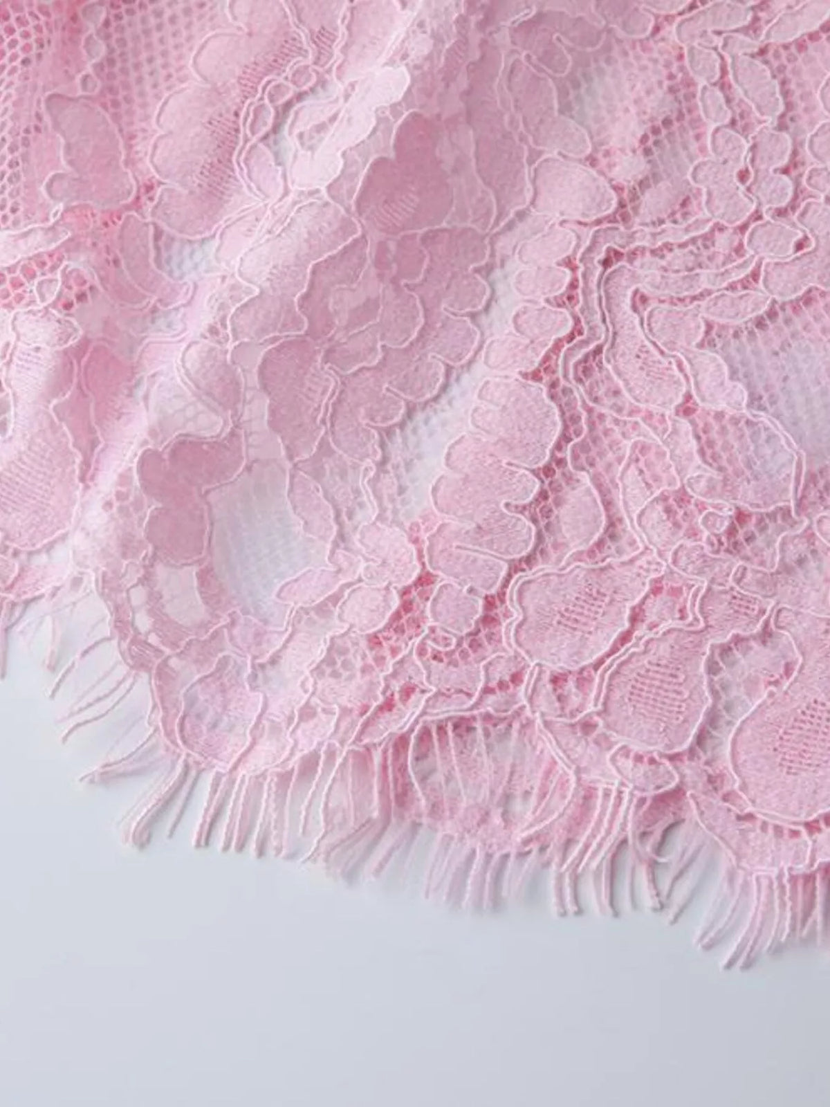 Pink lace long-sleeve midi dress, hem detail.