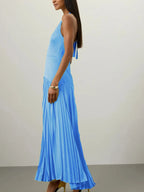 Blue pleated halter-neck maxi dress, side view.