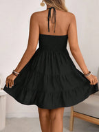 Black smocked halter tiered mini dress, back view
