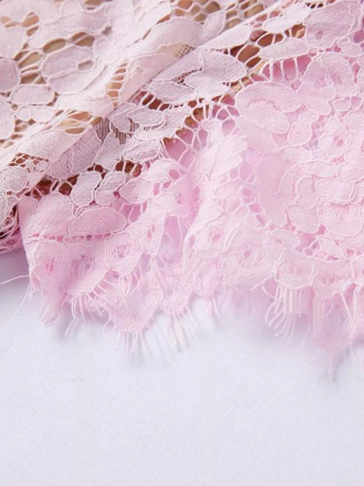 Pink short-sleeve lace mermaid midi dress, hem detail.