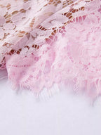 Pink short-sleeve lace mermaid midi dress, hem detail.