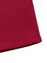 Red pearl-trim v-neck bodycon dress, hem detail.