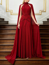 Red ruched halter cape maxi dress, front view.