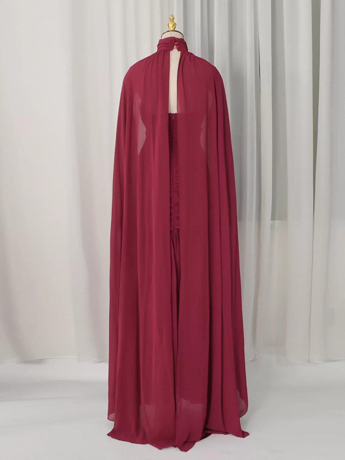 Burgundy ruched halter cape maxi dress, back view.