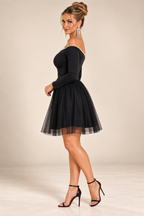 Black pearl-trim off-shoulder mini dress, side view.