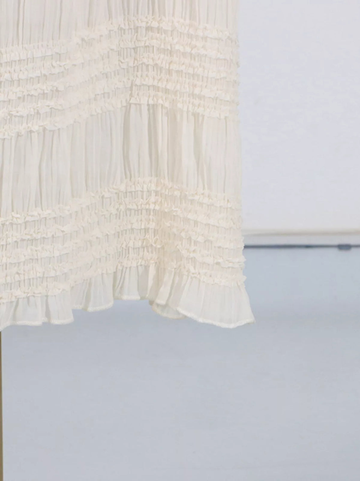 Ivory ruched halter neck maxi dress, hem detail.