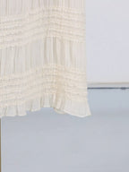 Ivory ruched halter neck maxi dress, hem detail.