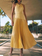 Yellow pleated halter-neck maxi dress, front view.