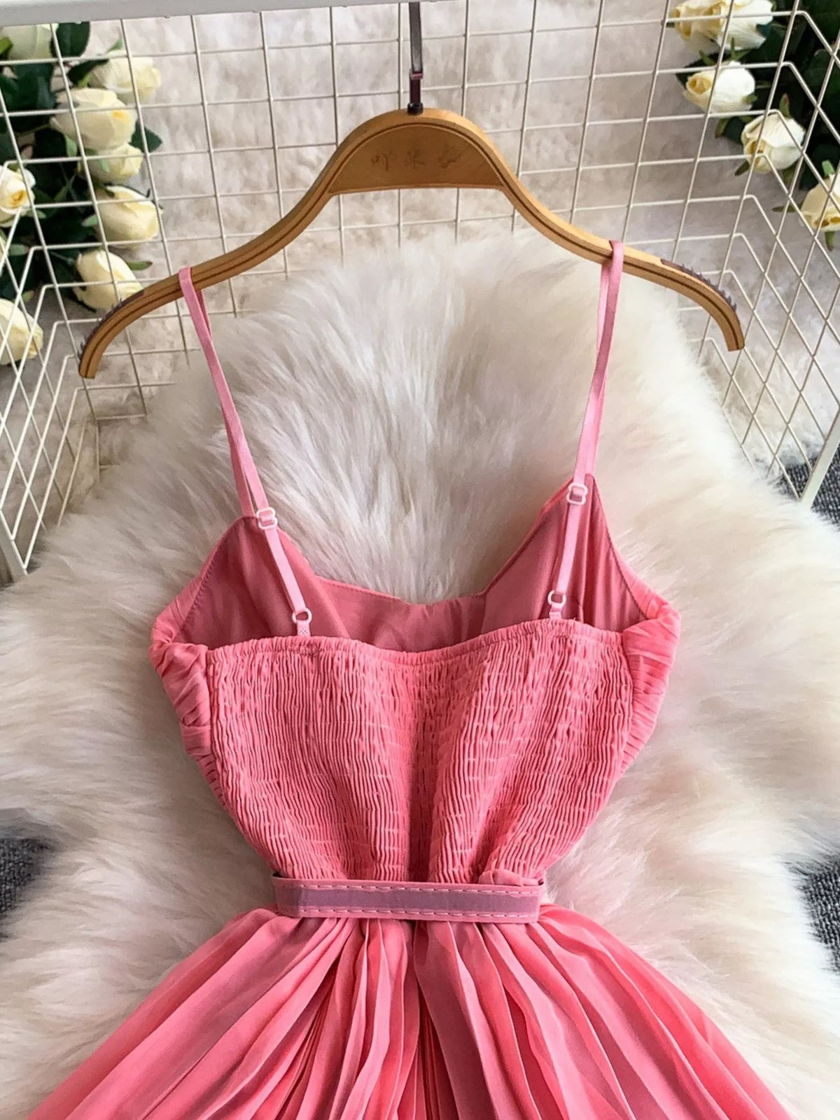 Pink pleated layered spaghetti-strap midi dress, bodice detail.