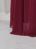 Burgundy ruched halter cape maxi dress, hem detail.