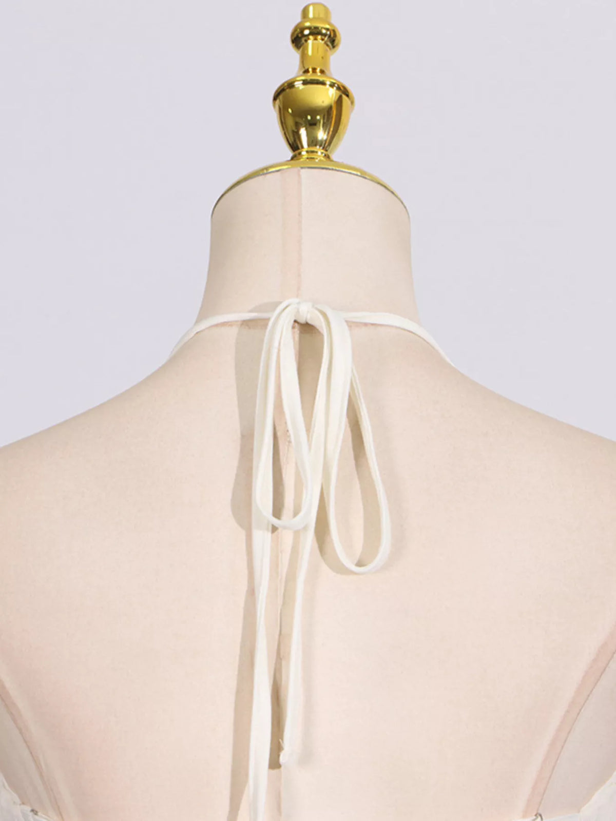 Ivory ruched halter neck maxi dress, back neckline detail.