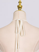 Ivory ruched halter neck maxi dress, back neckline detail.